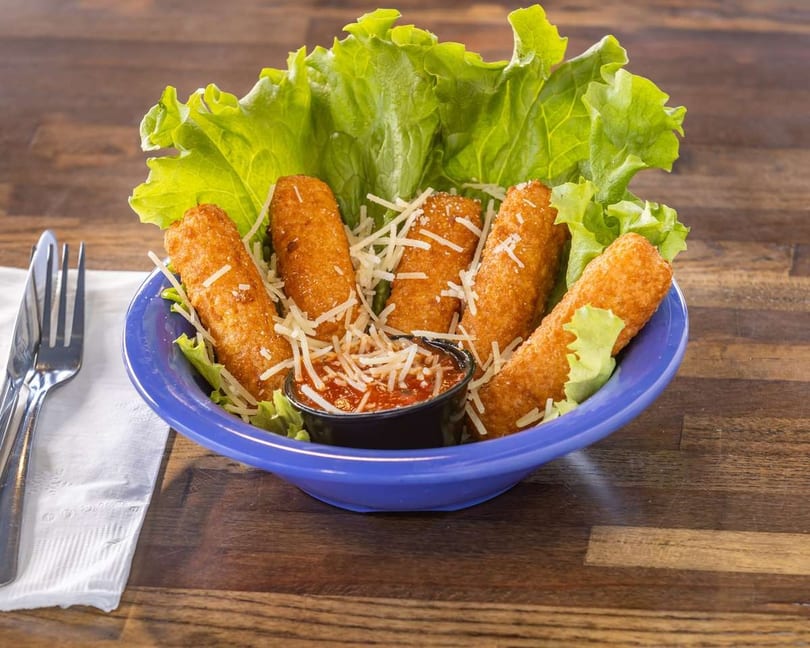 Golden-brown mozzarella sticks with shredded cheese, marinara sauce, and lettuce in a blue bowl.